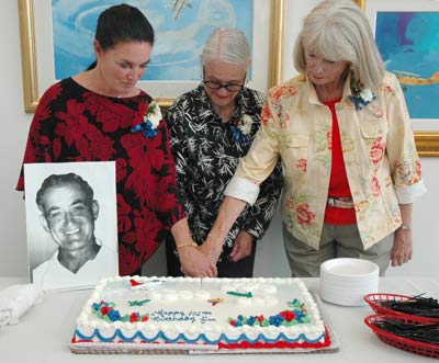 The daughters of Jim Walker cut the birthday cake